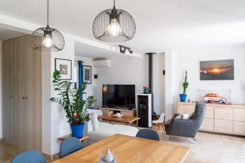 - un salon avec une table, des chaises et une télévision dans l'établissement Les lauriers, au Plan-de-la-Tour