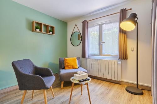 a living room with a chair and a lamp at Domaine du Gros Chêne - terrasses avec jacuzzis privatifs in Ablon