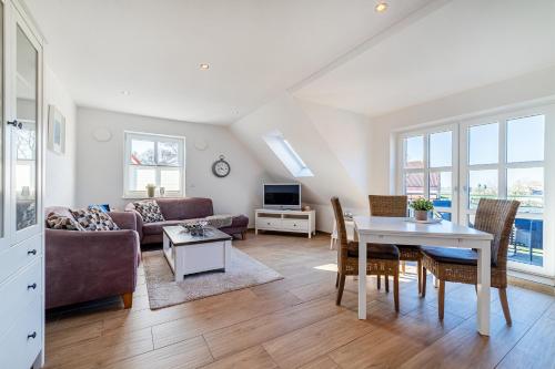 a living room with a couch and a table at Mühlenblick 04 in Greetsiel