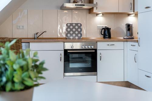 a kitchen with white cabinets and an oven at Mühlenblick 04 in Greetsiel