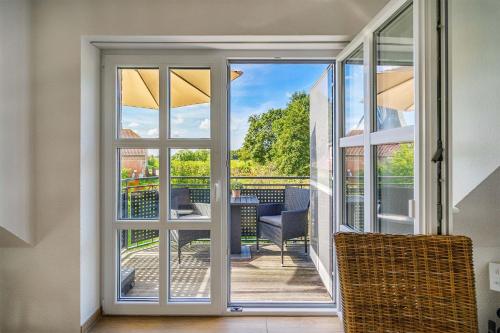 a sliding glass door leading to a patio with a table at Mühlenblick 04 in Greetsiel