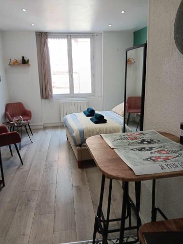 une pièce avec un lit et une table dedans dans l'établissement Le Petit B - Lit Neuf- Hyper centre, à Dieppe