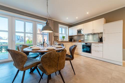 a kitchen and dining room with a table and chairs at Hus in Luv in Greetsiel