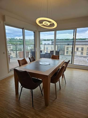 une salle à manger avec une table et des chaises et une grande fenêtre dans l'établissement Appartement neuf en duplex, à Saint-Maur-des-Fossés