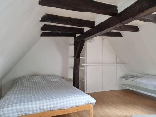 a bed in a room with wooden beams at Duplex Cité Plantagenêt - 2 Voyageurs - WIFI in Le Mans