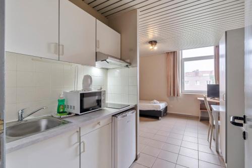 a kitchen with a sink and a microwave at Budget Flats Leuven in Leuven