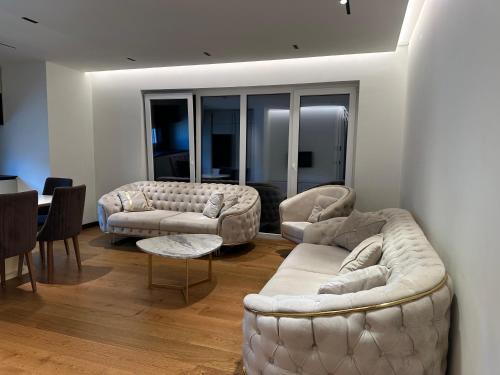 a living room with two couches and a table at Skyline Exclusive in Peje