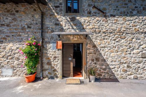 a stone building with a doorway with two plants at Casale di Polly in Garfagnana in Minucciano