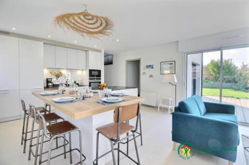 une cuisine et une salle à manger avec une table et des chaises dans l'établissement Ty anel, à Auray