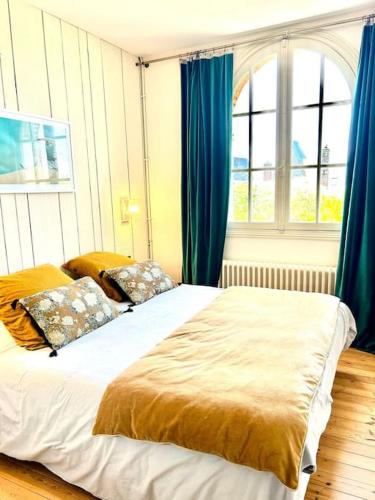 - une chambre avec 2 lits et des rideaux bleus dans l'établissement Villa Marengo, jardin privatif, à Trouville-sur-Mer