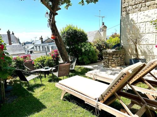 a group of chairs and a table in a yard at Villa Marengo, jardin privatif in Trouville-sur-Mer