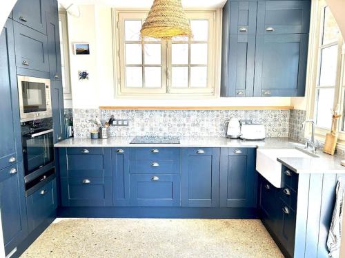 a kitchen with blue cabinets and a sink at Villa Marengo, jardin privatif in Trouville-sur-Mer