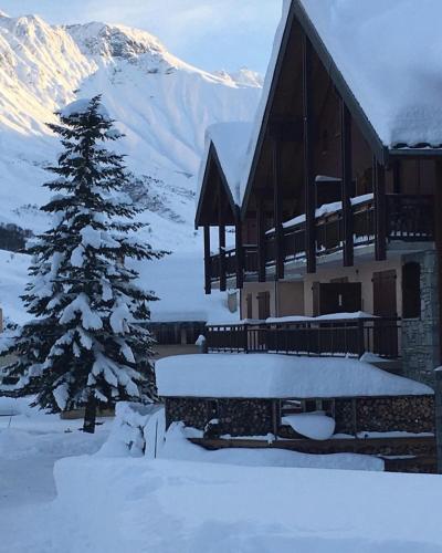 a snow covered house with a christmas tree in front of it at Charmant Duplex Au Pied Des Pistes in Albiez-Montrond