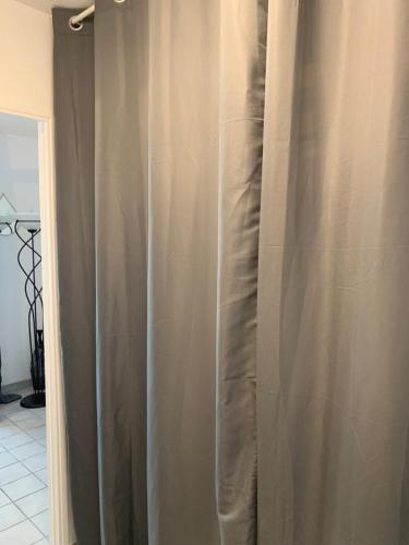- un rideau de douche dans une salle de bains située à côté d'une porte dans l'établissement Maison proche village naturiste - 7 personnes, au Cap d'Agde