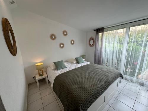 une chambre avec un lit et une grande fenêtre dans l'établissement Maison proche village naturiste - 7 personnes, au Cap d'Agde