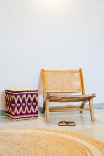 a wooden chair and a box next to a bench at Planeta Country House & Beach Club in Menfi