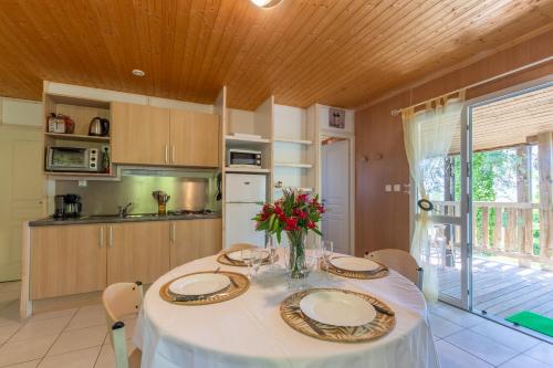 d'une cuisine avec une table avec des assiettes et des fleurs. dans l'établissement Chalet Chloé - Mas Lachamp, à Gravières
