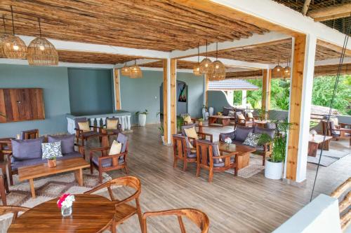 a restaurant with wooden tables and chairs and tables and chairs at Mnana Beach Bungalows in Michamvi