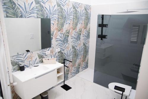 a bathroom with a shower and a sink and a mirror at Welchome Apartment and Luxury Rooms in Grumo Appula