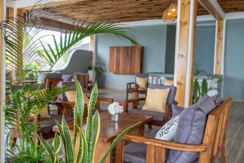 a living room with wooden furniture and plants at Mnana Beach Bungalows in Michamvi