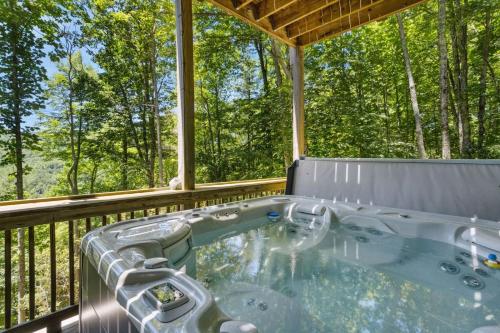 a hot tub on a deck with trees at Red Bear Run in Beech Mountain