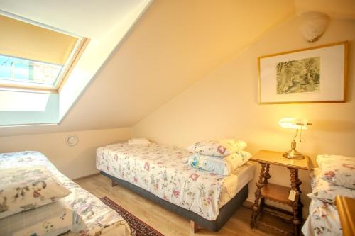 a attic bedroom with two beds and a table at Nina Kordon Guesthouse in Alatskivi