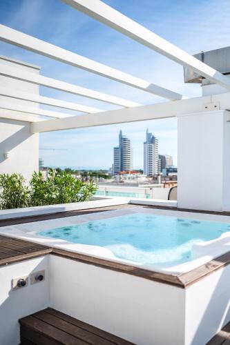a hot tub on a balcony with a view of the city at Hotel Orizzonte in Lido di Jesolo