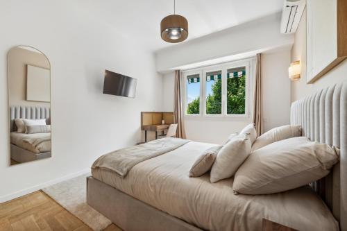 une chambre avec un grand lit et un miroir dans l'établissement Luxueux, spacieux et tout équipé à 5 min du port, à Nice