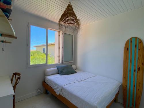 ein kleines Schlafzimmer mit einem Bett und einem Fenster in der Unterkunft Maison 300 m de la plage avec un bel extérieur in Gruissan