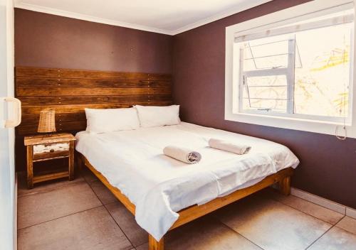 une chambre avec un lit avec deux serviettes dessus dans l'établissement Surfhostel Cape Town, au Cap