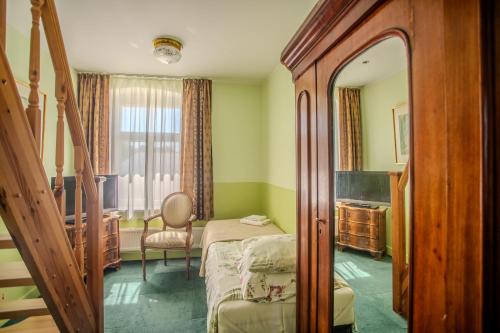 a bedroom with a bed and a chair and a mirror at Nina Kordon Guesthouse in Alatskivi