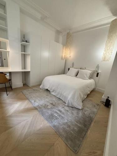 - une chambre blanche avec un lit et un tapis dans l'établissement Modern apt Canal st Martin, à Paris