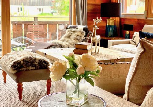 a living room with a vase of flowers on a table at Chalet Valambrun - unashamedly luxurious Alpine living in Les Gets