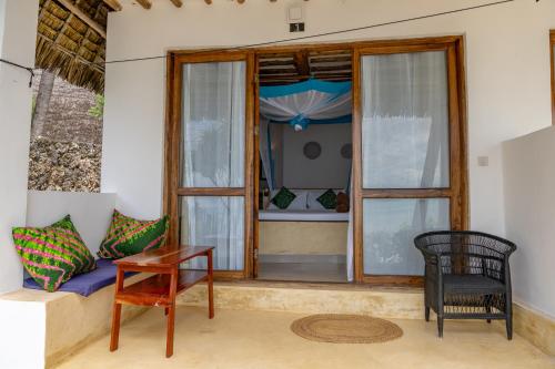 a room with a couch and a table and a window at Mnana Beach Bungalows in Michamvi