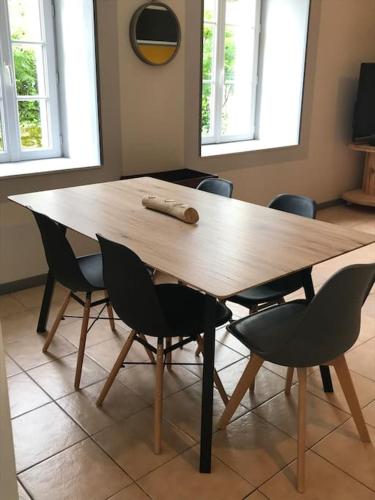 a wooden table with chairs around it with a wooden at Gîte cosy à la campagne Le temps d'une pause in Neuvy-Bouin