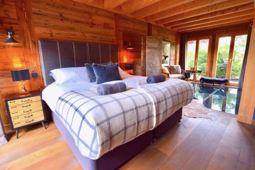 a bedroom with a large bed in a room with wooden walls at Chalet Valambrun - unashamedly luxurious Alpine living in Les Gets