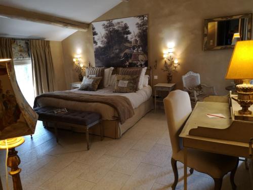une chambre avec un grand lit et un bureau dans l'établissement Domaine de Mejeans - Teritoria, à Alleins
