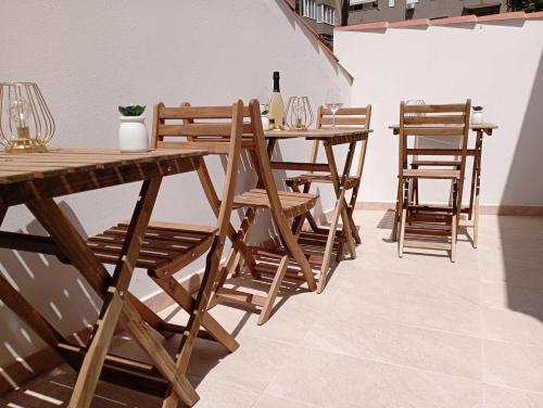 a group of wooden tables and chairs in a room at NIU Rooms in Oristano