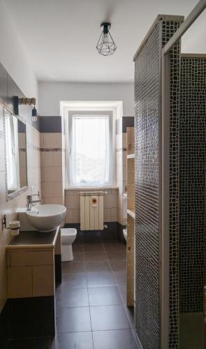 a bathroom with a sink and a toilet and a window at Casalebellavista in Tarquinia