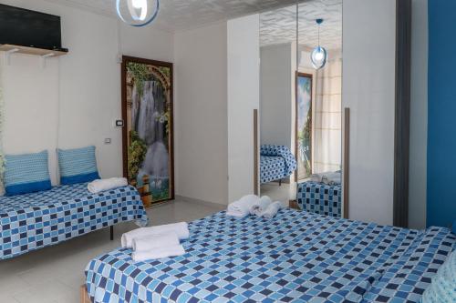 two beds in a room with blue and white at Il Girasole in Buccino