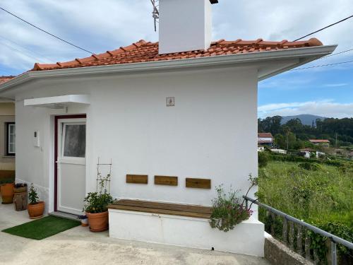 a white house with a bench in front of it at Casa do Montinho in Caminha