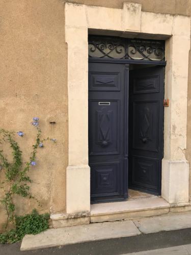 a black door on the side of a building at le Petit in Coursan
