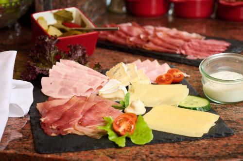 a bunch of different types of meats and cheese at Hotel SCHNEIDER in Allersberg