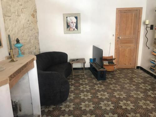 a living room with a couch and a television at le Petit in Coursan