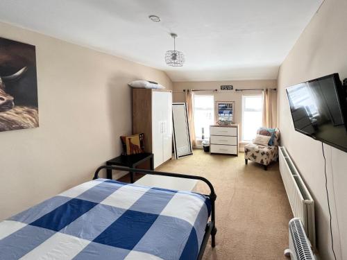 ein Schlafzimmer mit einem Bett und einem Flachbildfernseher in der Unterkunft Harbour Townhouse in Portrush