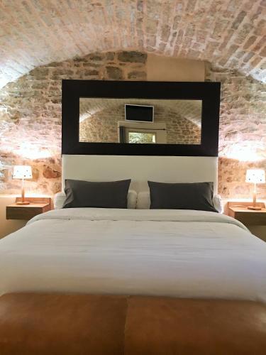 une chambre avec un grand lit blanc avec un mur de briques dans l'établissement Appartement La Borde, à Dijon