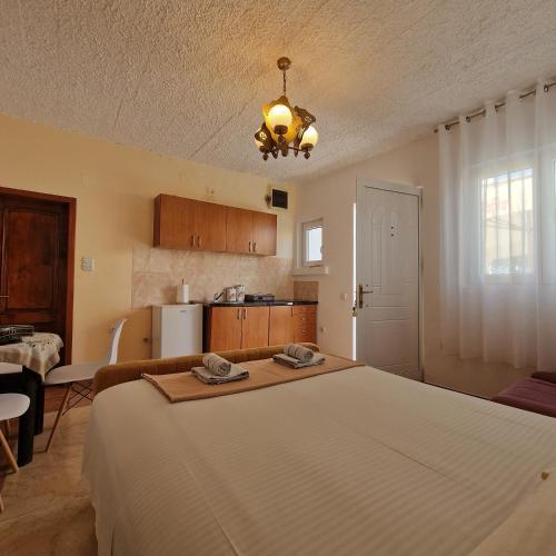 a bedroom with a large bed and a kitchen at Apartmani Vlahović in Sutomore