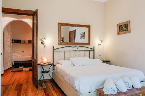a bedroom with a large white bed with a mirror at Doriana's House with Garden & Parking in Maslianico