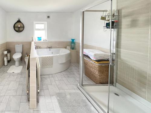 ein Badezimmer mit Badewanne und Dusche in der Unterkunft Harbour Townhouse in Portrush