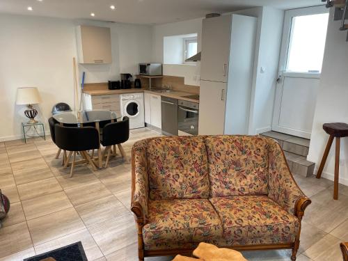 un salon avec un canapé et une table et une cuisine dans l'établissement Le grenier à grains - Lampaul-Guimiliau, à Lampaul-Guimiliau